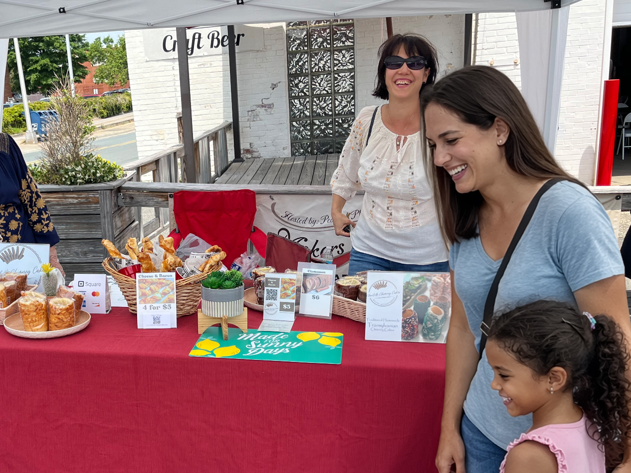 Happy vendor connecting with customers at a pop-up market